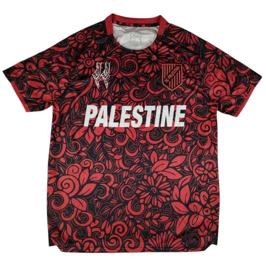 Forside af fodboldtrøje i rød blomstermønster med professionelt broderet FCPalestina-emblem og palæstinensisk flag-badge