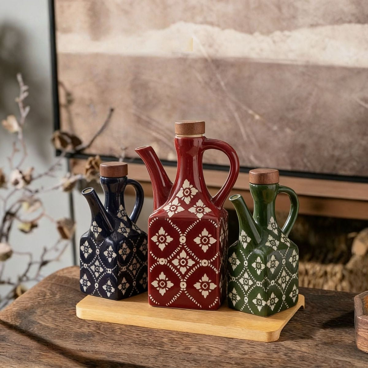 En lille blå, en stor rød og en lille grøn keramisk olivenolieflaske