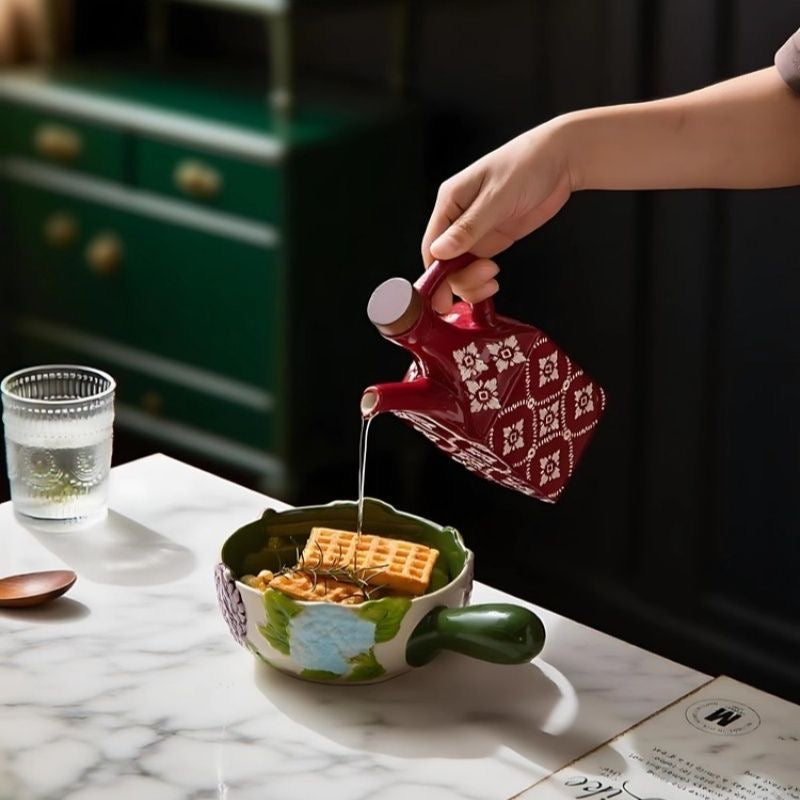 Rød keramisk olivenolieflaske i brug