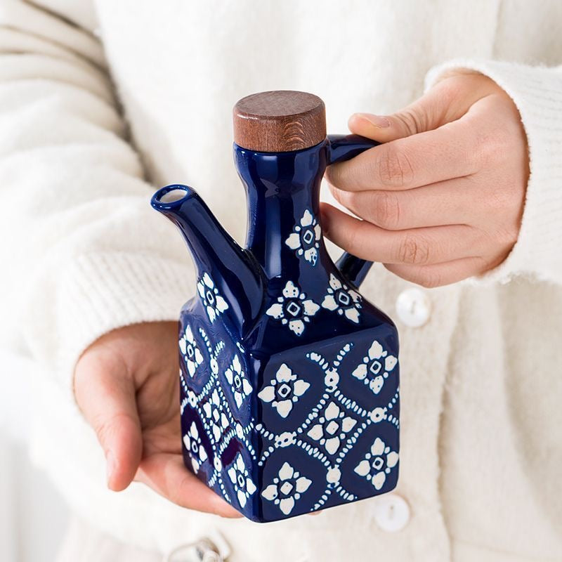 Blå keramisk olivenolieflaske closeup hånd