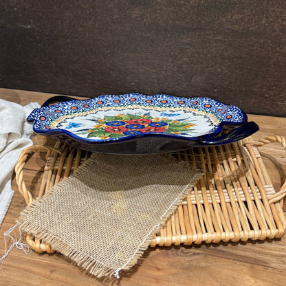 Detaljebillede af keramikfad med røde blomster og sommerfugle til farverig borddækning