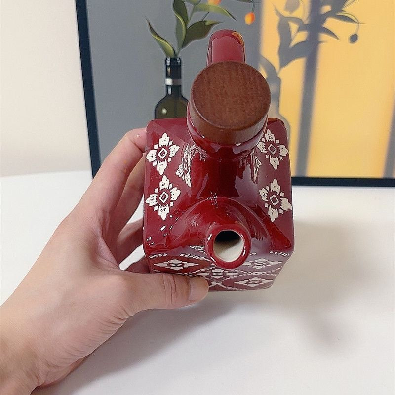 rød keramisk olivenolieflaske med trælåg