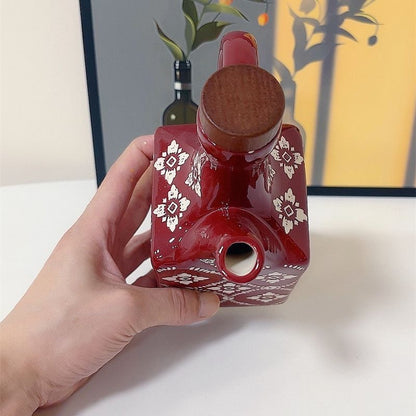 rød keramisk olivenolieflaske med trælåg